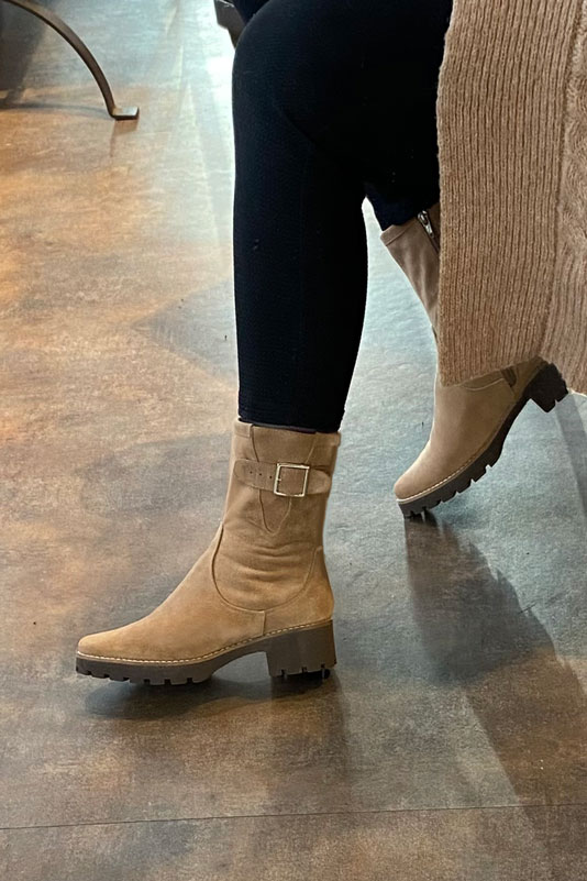 Tan beige women's ankle boots with buckles on the sides. Round toe. Low rubber soles. Worn view - Florence KOOIJMAN